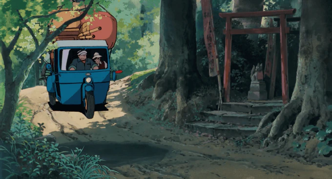 Image of a moving truck passing a roadside shrine